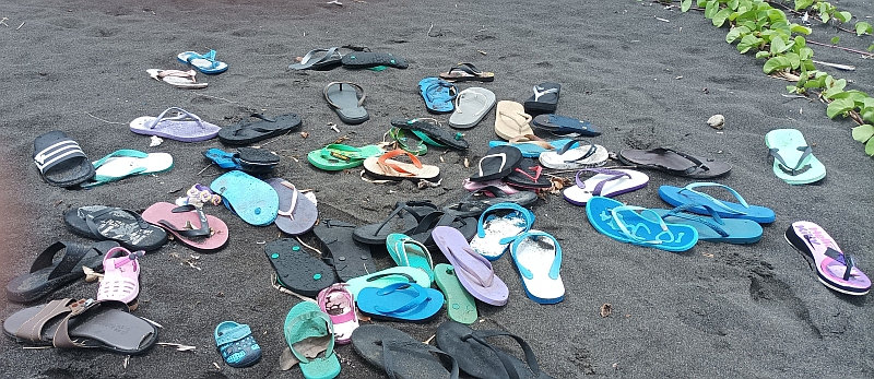 Schuhe am schwarzen Strand